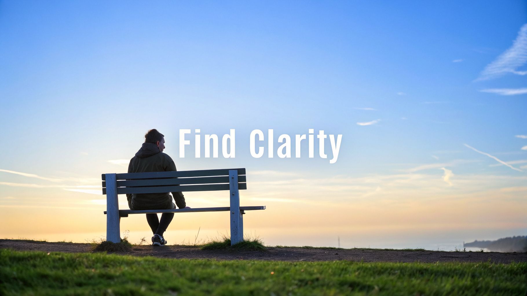 A person sits on a bench, looking at a serene sunrise or sunset over a misty landscape.