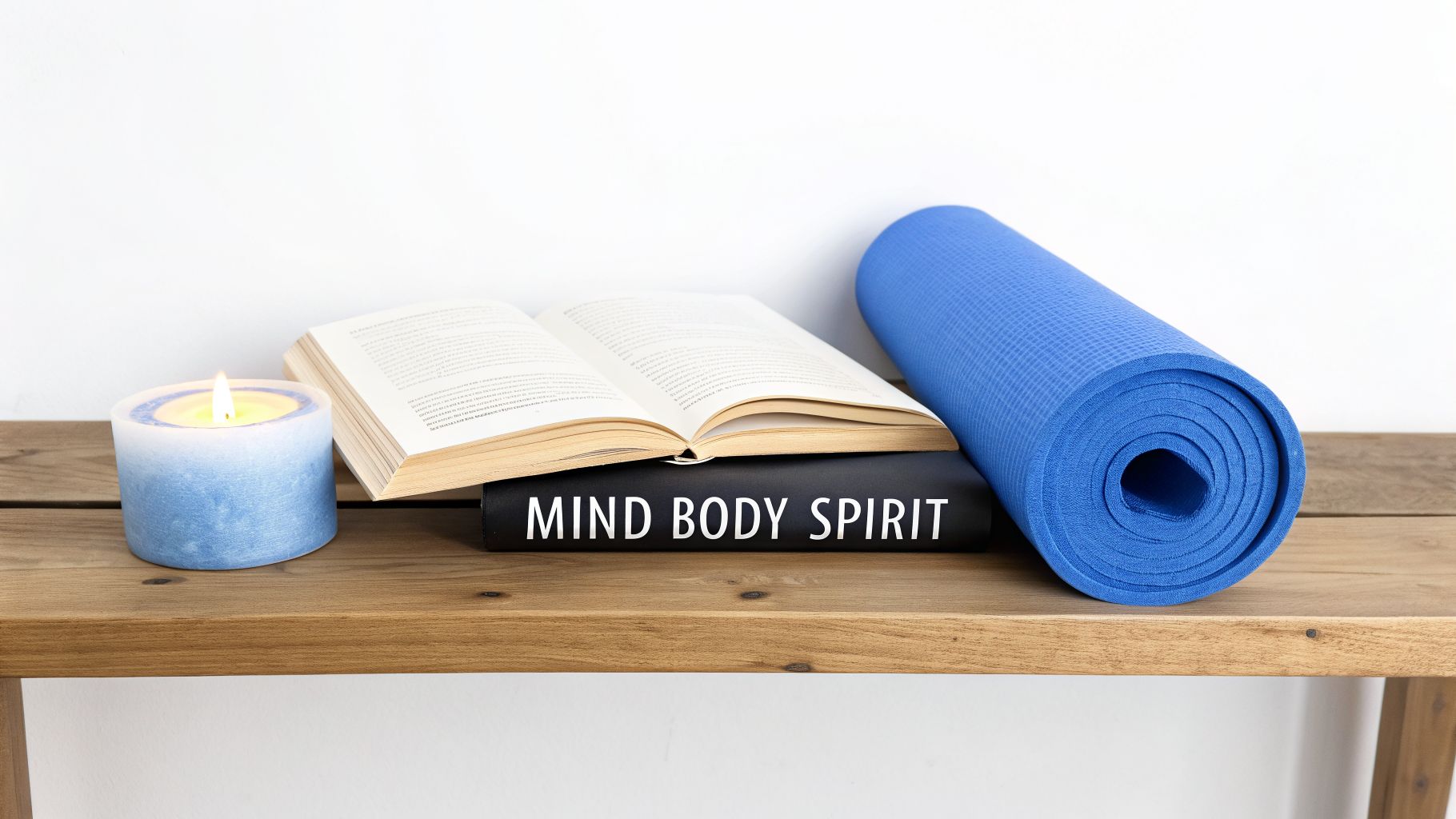 A blue candle, an open book, a 'MIND BODY SPIRIT' book, and a yoga mat on a wooden shelf.