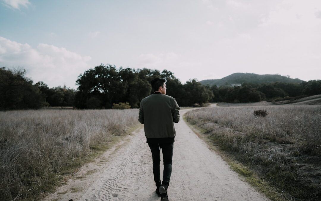 person walking forward on a peaceful path holding scripture cards