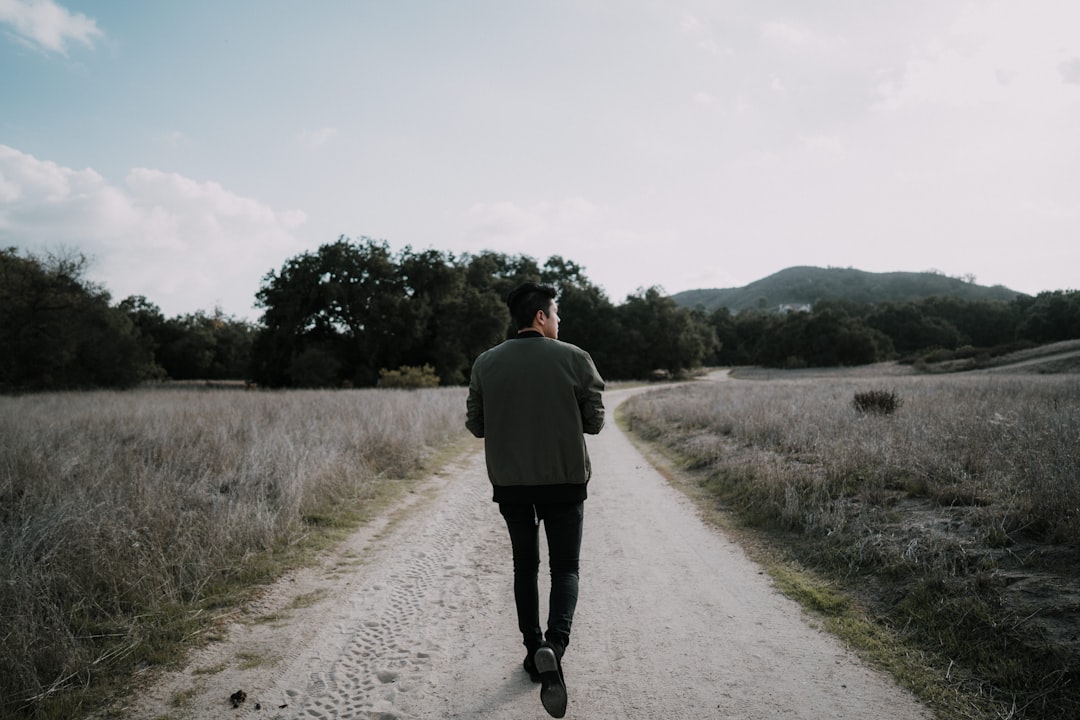 person walking forward on a peaceful path holding scripture cards